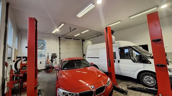 Piros BMW és fehér kisbusz a Grantech műhelyében