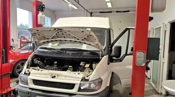 Fehér Ford Transit nyitott motorháztetővel