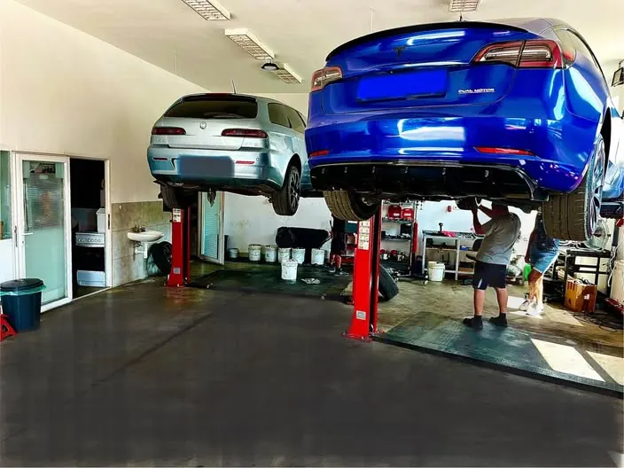Kék Tesla Model 3 emelőn a Grantech műhelyében