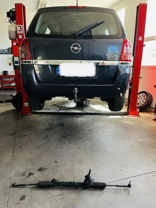 Opel Zafira emelőn, előtte a padlón a beszerelésre váró kormánymű