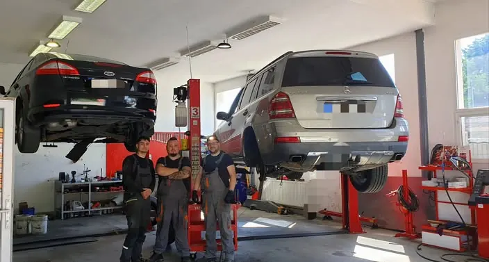 A Grantech szerelői két emelőn álló autó előtt